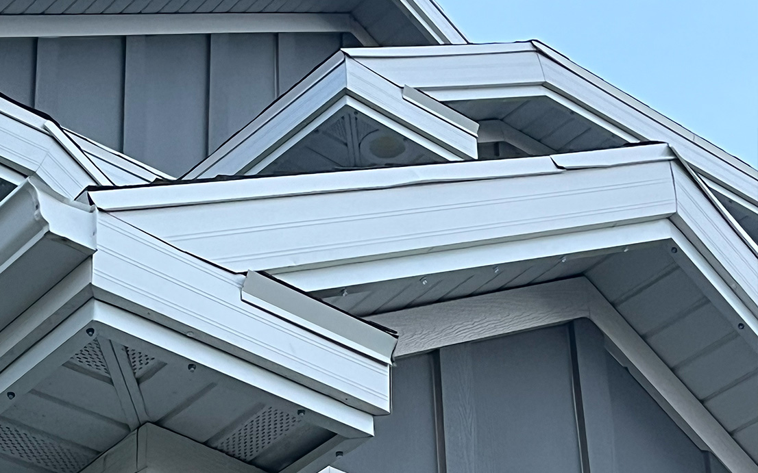Close-up of a slim color-matched LED track installed discreetly under a home soffit during the day